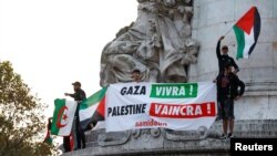 Los manifestantes sostienen banderas palestinas y una pancarta que dice "Gaza vivirá, Palestina derrotará" durante una manifestación no autorizada en París, Francia, el 12 de octubre de 2023. 