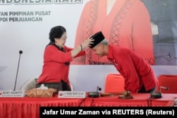 Mantan Presiden Megawati Soekarnoputri mengenakan kopiah kepada Ganjar Pranowo, caleg PDIP pada Pilpres 2024, di Bogor, Jawa Barat, 21 April 2023. (Foto: Jafar Umar Zaman via REUTERS)