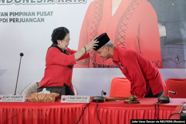 Mantan Presiden Megawati Soekarnoputri mengenakan kopiah kepada Ganjar Pranowo, caleg PDIP pada Pilpres 2024, di Bogor, Jawa Barat, 21 April 2023. (Foto: Jafar Umar Zaman via REUTERS)