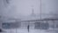A person stands near a bus station amid heavy snowfall in Randers, Denmark, Jan. 3, 2024. 