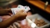 A customer pays for pork meat in a local market, in Buenos Aires, Argentina March 14, 2023. Argentina's annual inflation rate tore past 100% in February.