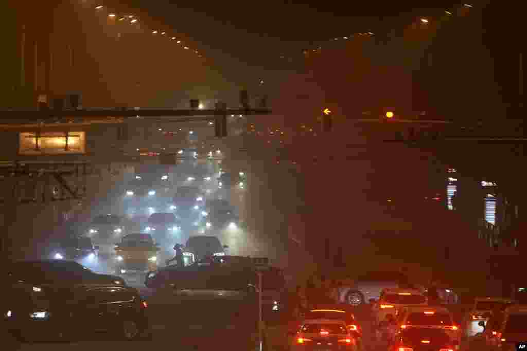 A cyclist crosses the street as a sand storm sweeps through Beijing, China.