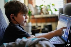 Phoenix Blalack, 6, works with a tutor on his laptop in his Indinapolis home, Tuesday, March 7, 2023. (AP Photo/AJ Mast)