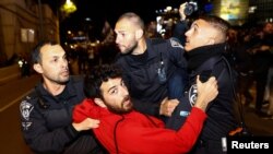 Police officers detain a man during a demonstration, as Israeli Prime Minister Benjamin Netanyahu's nationalist coalition government presses on with its contentious judicial overhaul, in Tel Aviv, Israel, March 18, 2023.