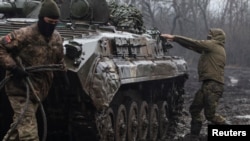 Ukrainian service members are seen next an infantry fighting vehicle near the frontline town of Bakhmut in Donetsk region, Ukraine Feb. 25, 2023.