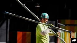 FILE - A construction worker carries scaffolding parts on March 14, 2024, in Boston. The unemployment rate jumped to 4.3% in July, the fourth consecutive month the rate has increased and the highest since Oct. 2021.