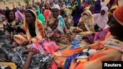 FILE - Harana Arabi Souleymane, a Sudanese refugee who is seeking refuge in Chad for a second time, waits to receive food supplements from World Food Programme (WFP), in Koufroun, Chad, May 11, 2023.