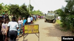 Locals gather at the cordoned scene outside the Mpondwe Lhubirira Secondary School, after militants linked to rebel group Allied Democratic Forces (ADF) killed and abducted multiple people, in Mpondwe, western Uganda, June 17, 2023. 