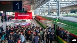 FILE - In this photo released by Xinhua News Agency, passengers line up to board a train of the Laos-China Railway at Kunming Railway Station in Kunming in southwestern China's Yunnan Province, Dec. 3, 2021. 