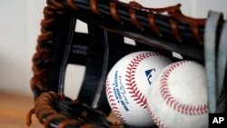 Un guante y pelotas de béisbol durante una práctica de primavera en en Goodyear, Arizona, EEUU, el 29 de marzo de 2022/