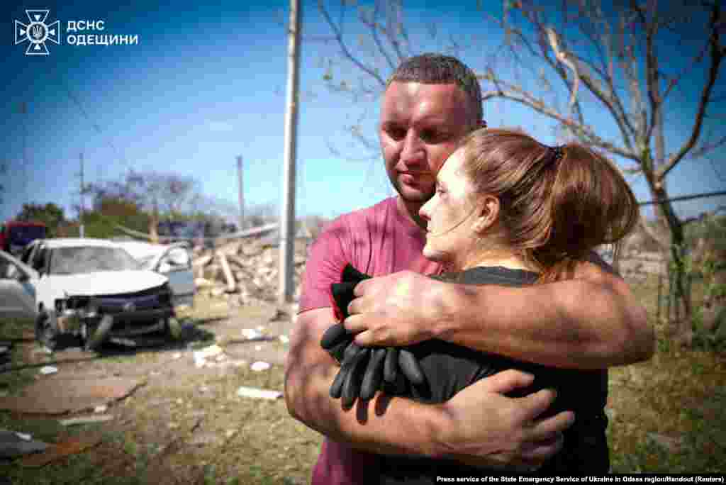 Local residents embrace each other at the site of a Russian missile strike in Odessa region, Ukraine.