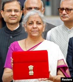 FILE: Menteri Keuangan India Nirmala Sitharaman mengangkat map berlogo Pemerintah India saat meninggalkan kantornya untuk menyampaikan anggaran persatuan di parlemen di New Delhi, India, 23 Juli 2024. (Altaf Hussain/Foto Arsip/REUTERS)