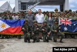 Menteri Pertahanan Australia Richard Marles (tengah), Menteri Pertahanan Filipina Gilberto Teodoro (kiri) dan Duta Besar Australia untuk Filipina Hae Kyong Yu (kanan) berfoto bersama para tentara Australia dan Filipina usai menyaksikan latihan bersama di Kota San Antonio, Provinsi Zambales, Jumat, 25 Agustus 2023. (Foto: Ted Aljibe/AFP)