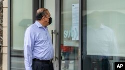 FILE - Attorney Randy Medina reads a notice posted on the door of a Silicon Valley Bank branch that reads, "FDIC Acts to Protect All Depositors of the former Silicon Valley Bank," in Pasadena, Calif., March 13, 2023.