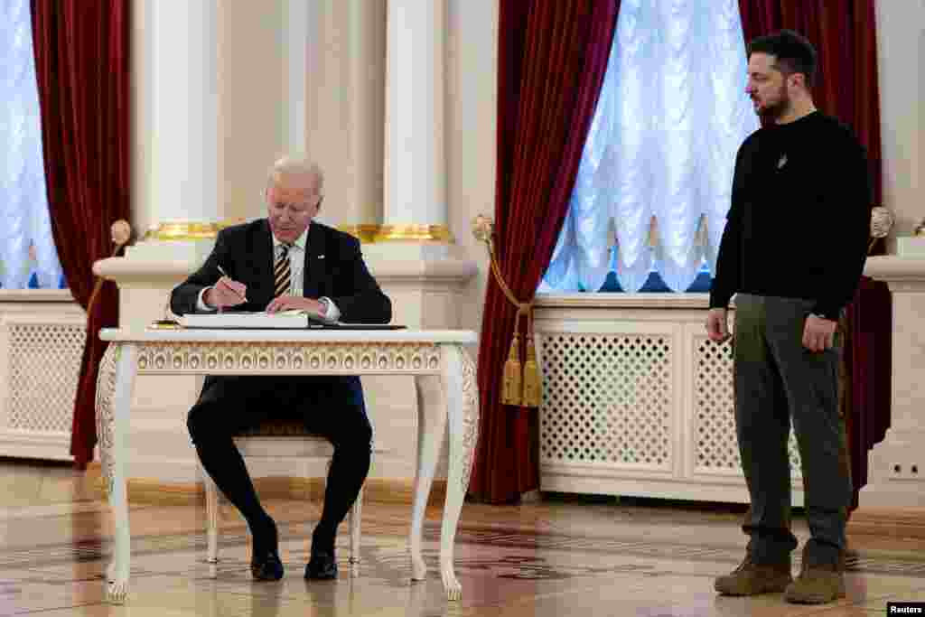 El presidente de Estados Unidos firma el libro de invitados en el Palacio Mariinsky, la residencia oficial del presidente ucraniano.