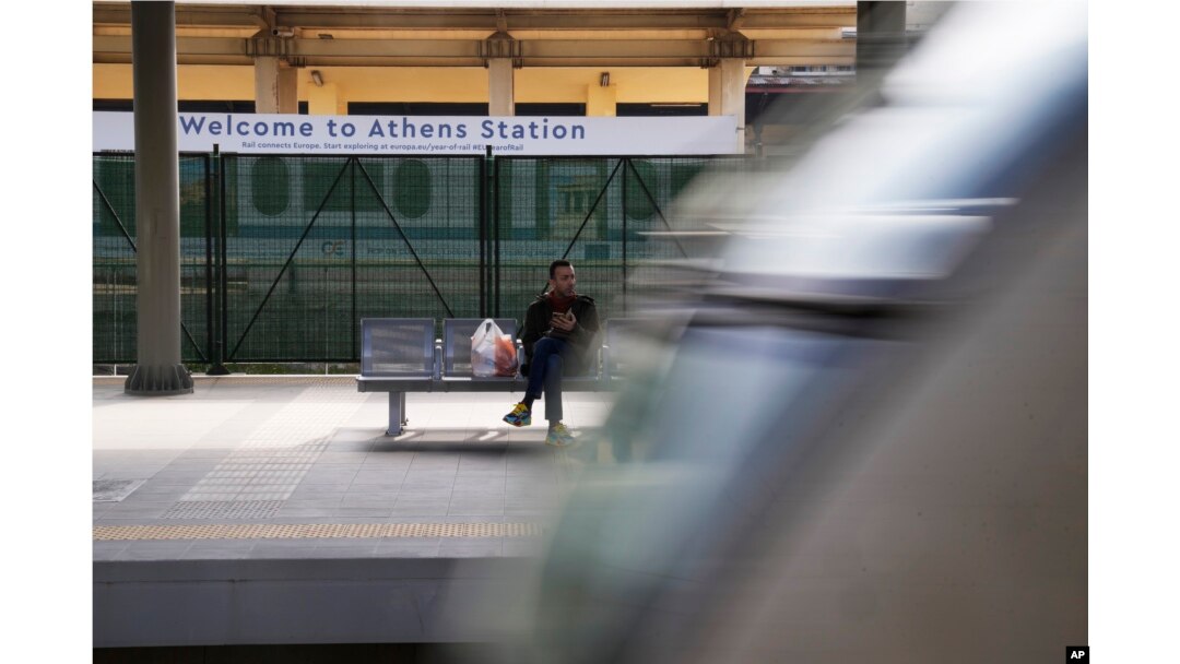 Seorang penumpang menunggu saat kereta bergerak dari stasiun utama di Athena, Yunani, Rabu, 22 Maret 2023. (AP/Thanassis Stavrakis)