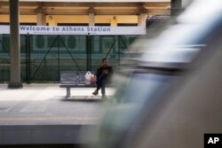 Seorang penumpang menunggu saat kereta bergerak dari stasiun utama di Athena, Yunani, Rabu, 22 Maret 2023. (AP/Thanassis Stavrakis)