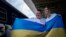 Ukrainian rapper alyona alyona, left, and singer Jerry Heil hold the Ukrainian flag as they pose for the media before departing from the main train station in Kyiv, Ukraine, April 25, 2024.