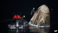 Support team members work around the SpaceX Dragon Endurance spacecraft shortly after it landed with four astronauts aboard in the Gulf of Mexico off the coast of Pensacola, Florida, March 12, 2024. (Joel Kowsky/NASA via AP)