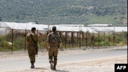FILE - Israeli soldiers patrol along the road by the security fence near Ibthan in central Israel separating it from the occupied West Bank, April 13, 2022. 