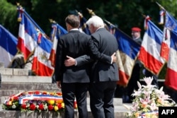 French President Macron (L) and German President Frank-Walter Steinmeier stand together as they pay their respects during a ceremony marking the 80th anniversary of the Oradour-sur-Glane massacre, June 10, 2024.