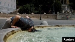 Seorang warga tampak membenamkan kepalanya ke dalam kolam air mancur di Piazza del Popolo di Roma, Italia, di tengah gelombang panas yang melanda pada 18 Juli 2023. (Foto: Reuters/Remo Casilli)