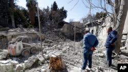 FILE - People inspect the damage to a medieval citadel after an early-morning Israeli airstrike in Damascus, Syria, Feb. 19, 2023.