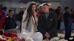 A couple stand at a makeshift memorial in front of the Crocus City Hall on the western outskirts of Moscow, March 27, 2024. The March 22 massacre at the venue was the deadliest extremist attack on Russian soil in nearly two decades.