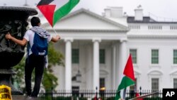 A man waves a flag during a pro-Palestinian rally at Lafayette Square outside the White House in Washington, Oct. 14, 2023.