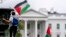 Seorang pria mengibarkan bendera Palestina dalam aksi pro-Palestina di Lafayette Square, di depan Gedung Putih, Washington, D.C., Sabtu, 14 Oktober 2023. (AP/Andrew Harnik)