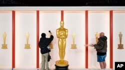 Workers prepare a backdrop during preparations for Sunday's 95th Academy Awards, March 10, 2023, in Los Angeles.