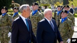 Brazilian President Luis Inacio Lula da Silva, right, and Portuguese President Marcelo Rebelo de Sousa review troops during a welcome ceremony in Lisbon, Portugal, April 22, 2023.