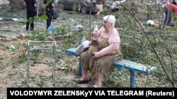 A resident sits near her residential building damaged by a Russian missile strike in Mykolaiv, Ukraine, July 19, 2024. Russian drones and missiles struck Ukraine overnight, killing two and hitting energy facilities and railway infrastructure across the country, said officials. 