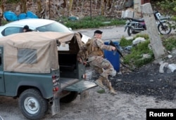 Seorang tentara Lebanon melompat dari kendaraan militernya di Al Qulaylah, pasca serangan udara Israel, di Lebanon selatan, 7 April 2023.