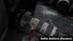 ARCHIVO - La cámara de un periodista cubierta de tierra y vidrios rotos se encuentra en el asiento trasero de un automóvil dañado, en medio del ataque de Rusia a Ucrania, en el centro de Járkov, Ucrania, el 11 de enero de 2024.