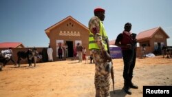 FILE: Security guards stand in front of a newly build two bedroom unit during the community re-opening ceremony, which was destroyed by Boko Haram armed militants in 2015, in Ngarannam, Borno State, Nigeria, October 22, 2022. 