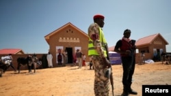 FILE: Security guards stand in front of a newly build two bedroom unit during the community re-opening ceremony, which was destroyed by Boko Haram armed militants in 2015, in Ngarannam, Borno State, Nigeria. Taken Oct.22, 2022.