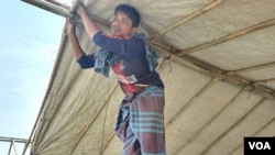 Mohammad Hussain’s shanty was gutted by fire March 5, 2023. Five days later, Islam is building a new shanty with the bamboo and tarpaulin he has got from the International Organization for Migration. (Noor Hossain/VOA)