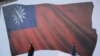 人们走过台湾新北市为竞选集会竖立起的一面台湾旗帜画像。（2024年1月12日）