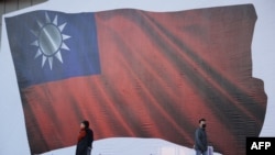 人們走過台灣新北市為競選集會豎立起的一面台灣旗幟畫像。 （2024年1月12日）
