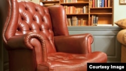 Pictured here is an traditional style armchair in front of some bookshelves.