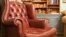 Pictured here is an traditional style armchair in front of some bookshelves.