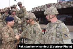 Pakistani and U.S. military personnel greet one another during a joint counter-terrorism exercise in Pabbi, Pakistan, on July 3, 2024.