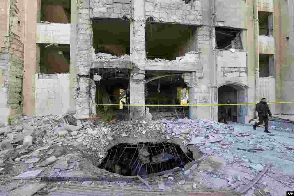 Members of security forces inspect a building damaged in a reported Israeli missile strike in Damascus, Syria.&nbsp;An Israeli missile strike aimed at Iranian and Hezbollah targets killed 15 people and destroyed a building in a Damascus neighborhood home to much of Syria&#39;s security apparatus, a war monitor said.&nbsp;