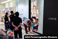 Para pekerja membersihkan area di sebuah toko furnitur tempat seorang remaja pria bersenjata ditangkap di dalam pusat perbelanjaan mewah Siam Paragon di Bangkok, Thailand, 4 Oktober 2023. (Foto: REUTERS/Athit Perawongmetha)