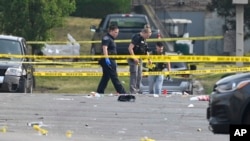 Investigators work the scene of an overnight mass shooting at a strip mall in Willowbrook, Illinois, June 18, 2023.