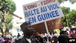 Un policier devant une manifestation contre les violences faites aux femmes à Conakry en novembre 2015.
