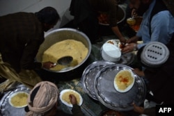 Muslim Afghanistan bersiap membagikan makanan di masjid saat berbuka puasa pada hari pertama bulan suci Ramadan di Kandahar, 11 Maret 2024. (Sanaullah SEIAM / AFP)