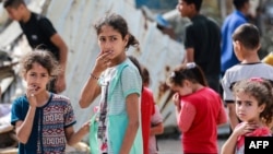 Niños palestinos reaccionan junto a los escombros de la casa de la familia Zaqout alcanzada durante los bombardeos israelíes nocturnos en Nuseirat, en el centro de la Franja de Gaza, el 30 de mayo de 2024.