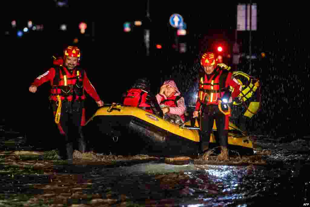 Firemen and civil protection rescuers evacuate a woman with a blow-up boat in Forli, after heavy rains caused major flooding in central Italy.